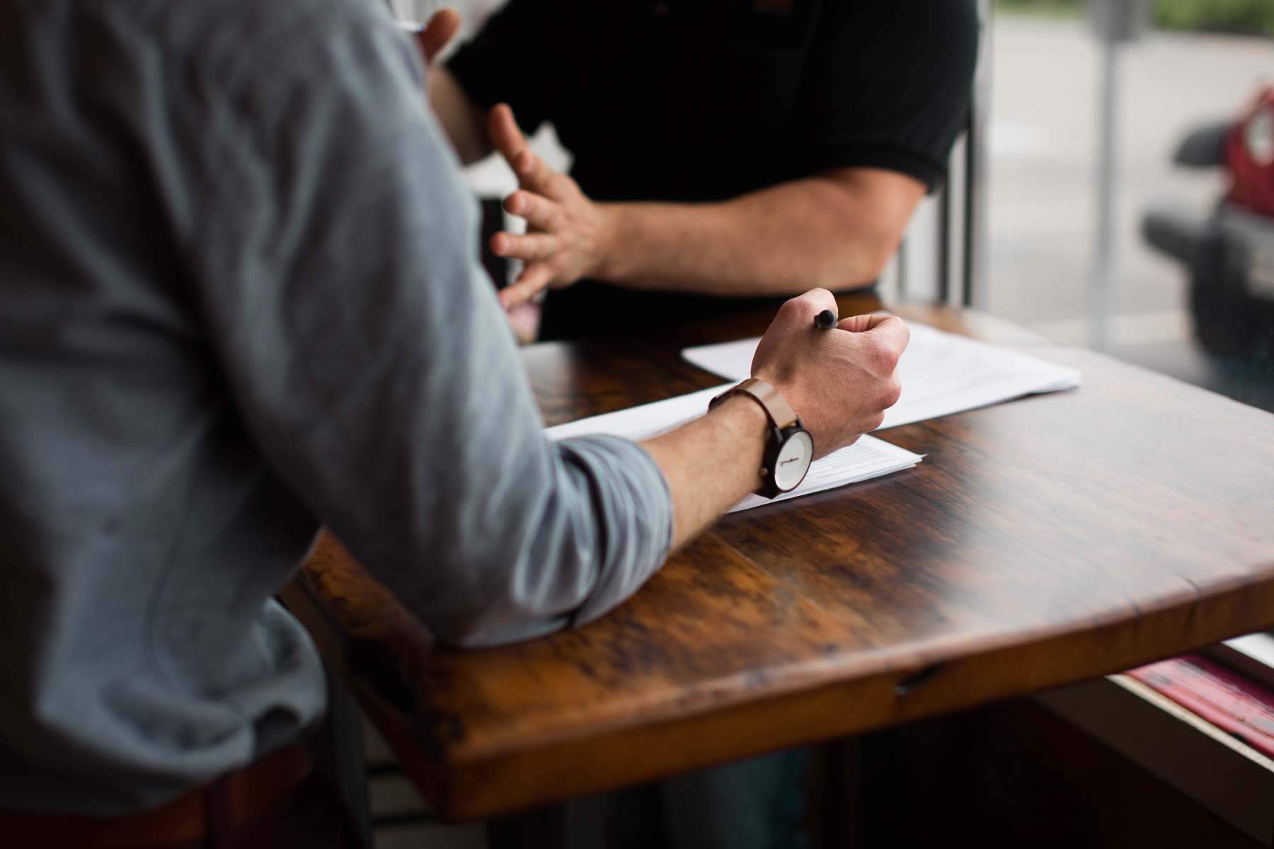 Two men planning and writing in a coffee shop