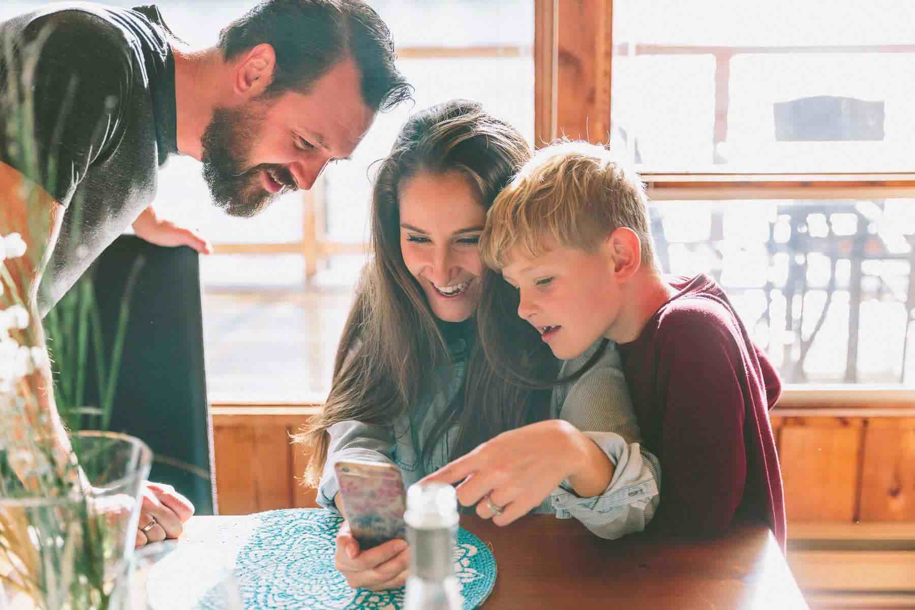 Family looking at something together on a phone in excitement