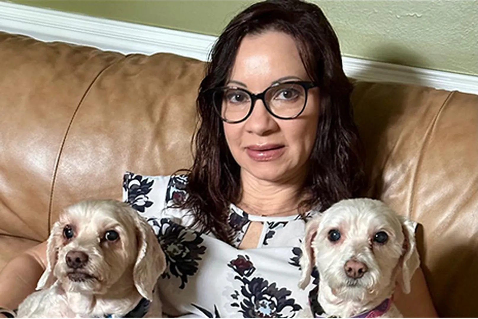 Abby Guadalupe, Mortgage Loan Officer, with two puppies on the couch.