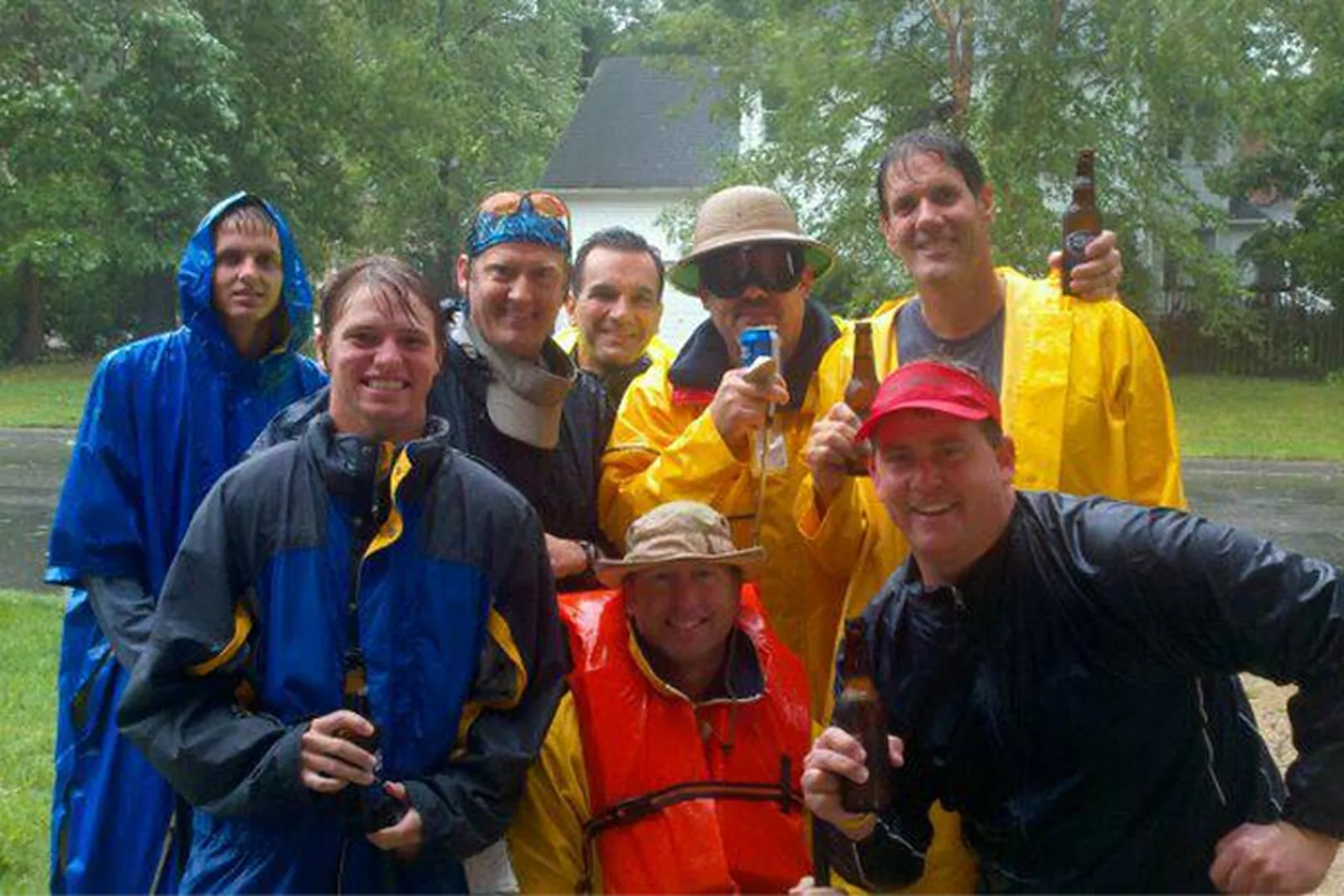 Brandon Blalock, Mortgage Loan Officer, wearing a raincoat in the rain with others.