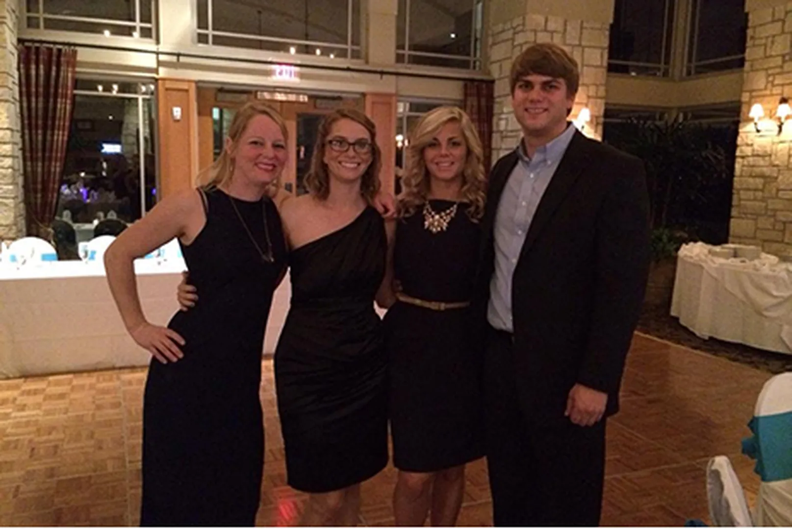 Laura Cooper, Senior Loan Officer, posing with a group of colleagues in elegant black dresses.